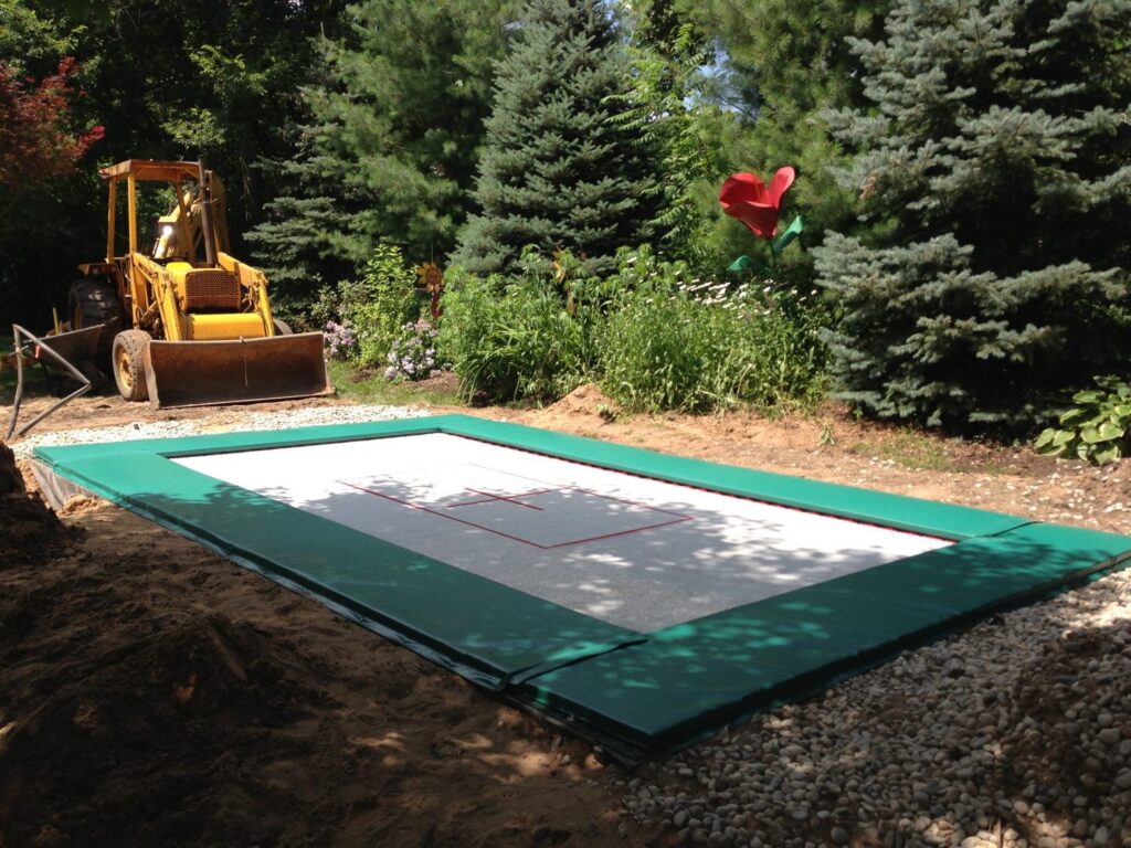 MaxAir will help you find an installer that nows how to put a trampoline in the ground. A dozer sits next to a finished trampoline pit.