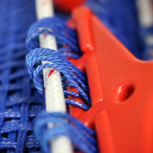 A close up of a trampoline string and the red clip attaching it.